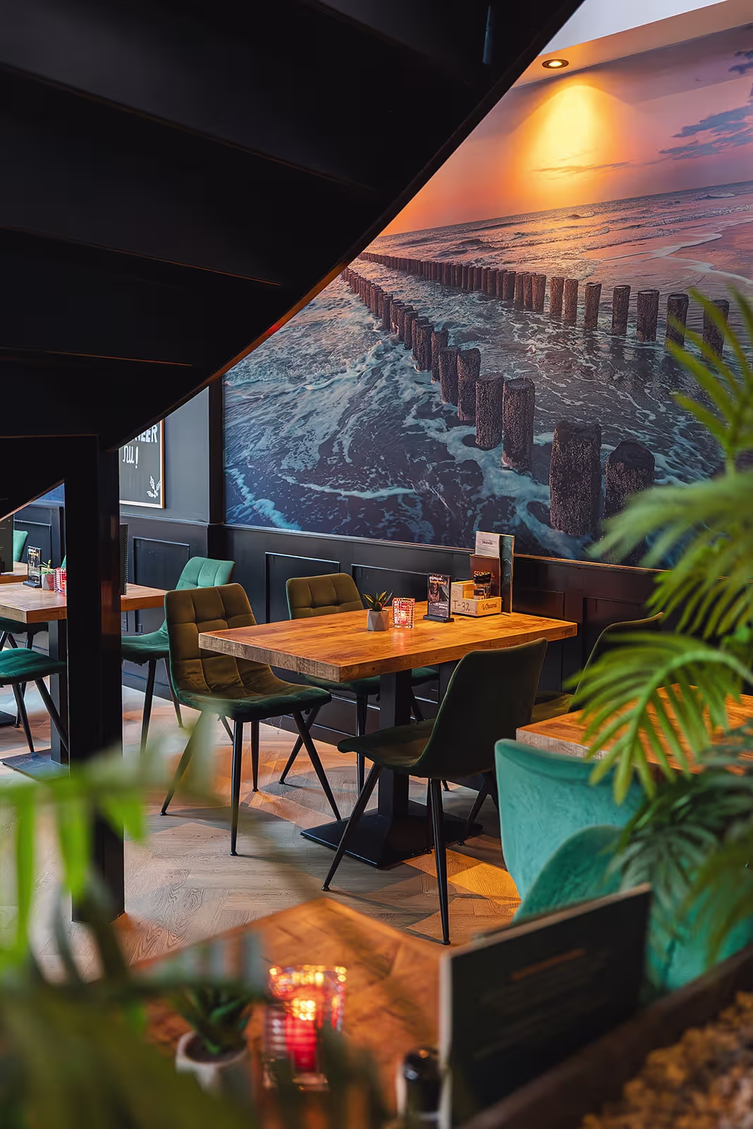 Interieur van Brasserie La Reine met groene stoelen en Zeeuwse wandfoto